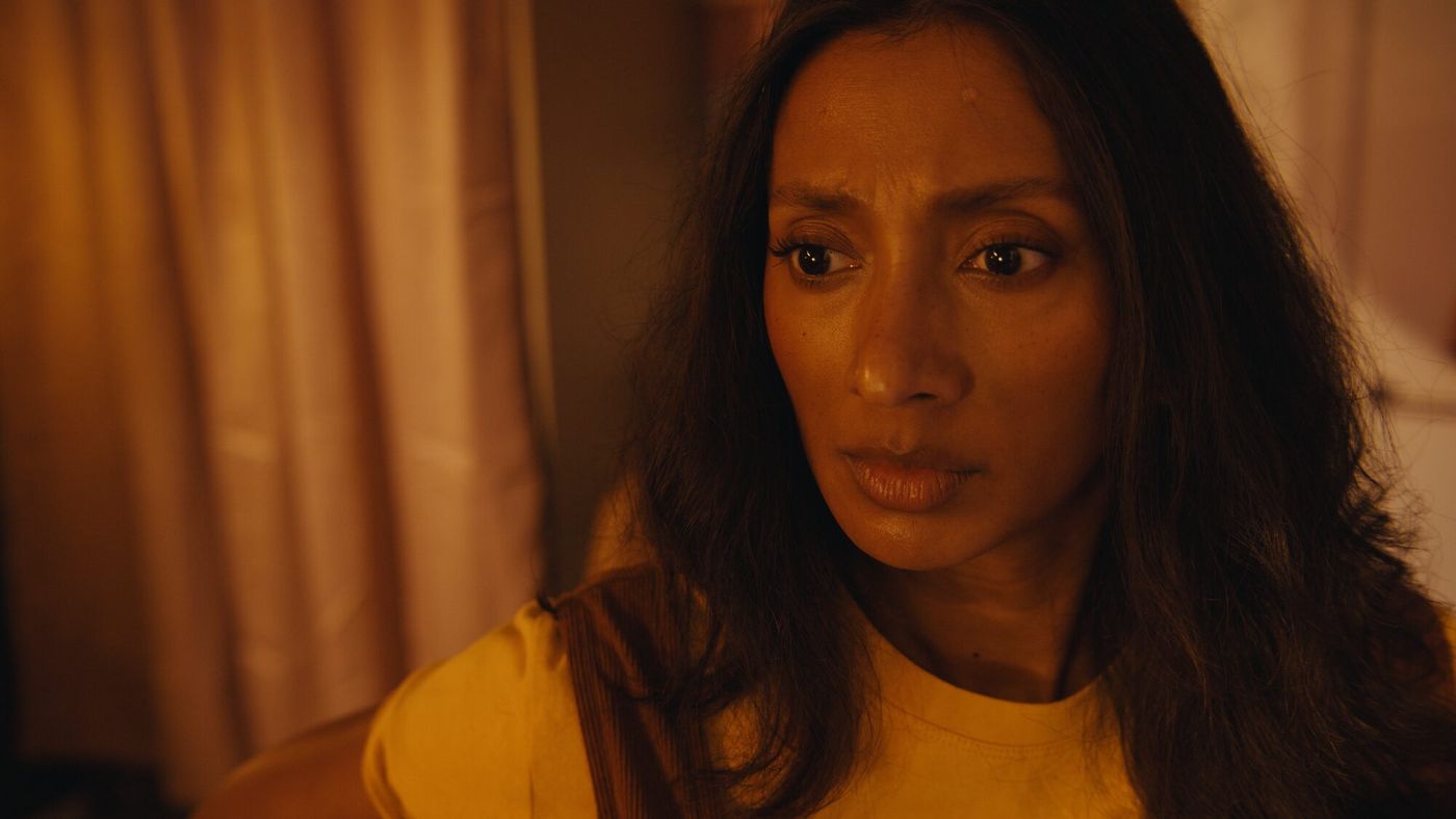 A close frame of Nikita looking off camera, lit warm