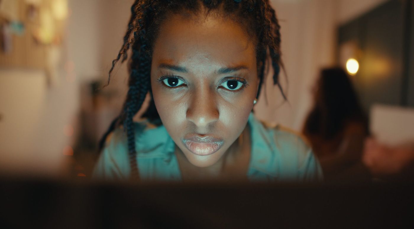 A close frame of Temi lit by a laptop screen